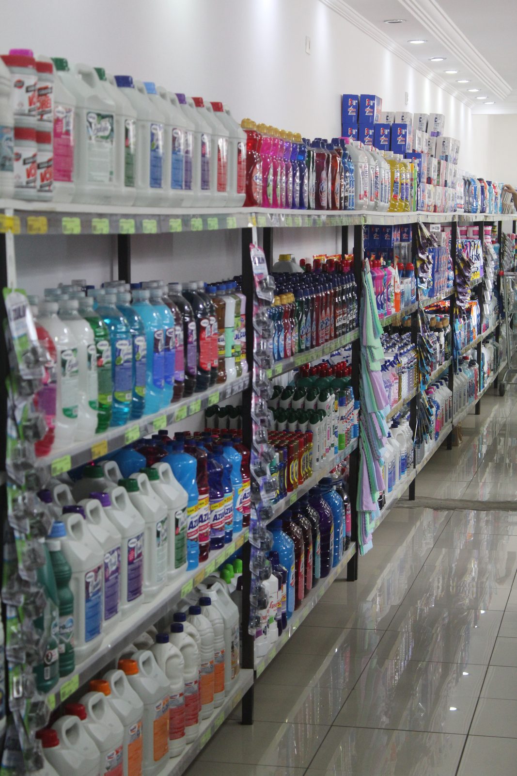 Corredor da loja de limpeza do Empório Dedo de Moça, com prateleiras cheias de produtos de limpeza