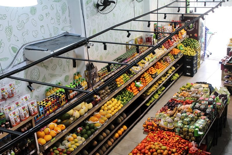 Hortifruti por dentro, com as bancas de frutas e legumes iluminadas por trilho de luz